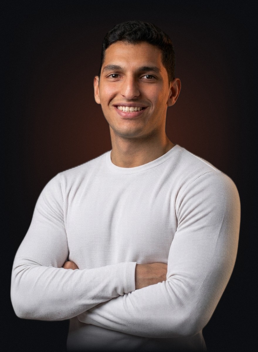 Abdelrahman (Bodz) smiling, arms crossed, in a white long-sleeve top